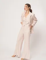 Pantalón negro de lino, tiro alto, corte palazo, con elástico en la pretina trasera, cierre delantero y broche interno. Tiene bolsillos laterales, dobladillo invisible y tajos a los costados.