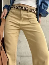 Pantalón de jean color beige, de corte recto y tiro alto, con bolsillos delanteros y traseros.