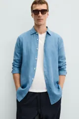 Camisa de corte regular fit confeccionada en tejido de lino, con cuello solapa, manga larga con puños abotonados y cierre frontal de botones.