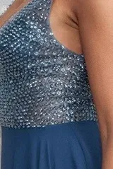 Vestido largo de fiesta color azul petróleo, con escote en V y cuerpo superior bordado con cuentas brillantes. Presenta falda fluida con tajo frontal profundo.