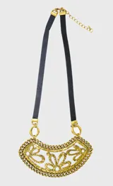 Collar con dije de flores caladas color dorado, con cadena de eslabones y tira de cuerina negra.