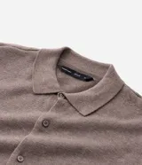Camisa de punto de manga larga con cuello tipo polo y cierre frontal abotonado. Presenta un diseño de textura fina y corte recto.
