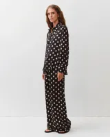 Pantalón negro de pierna ancha con estampado de lunares blancos, cintura elastizada, bolsillos laterales y confeccionado en mezcla de viscosa y seda.