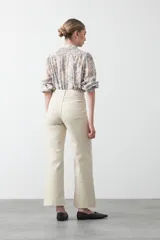 Pantalón de corte recto y tiro alto, color bordó, con costuras verticales frontales y bolsillos laterales.