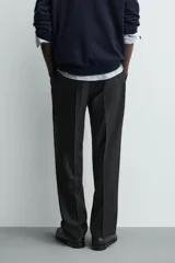 Pantalón de vestir regular fit color negro, con pliegues frontales y cierre con cremallera y botón.