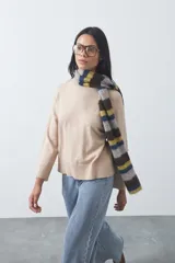 Polera de tejido liviano color negro con cuello alto y silueta relajada. Presenta mangas largas con puños ajustados y recortes laterales que aportan estructura al diseño.