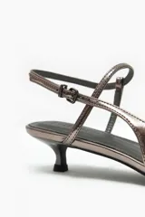 Zapato destalonado color peltre con punta fina, tira fina ajustable en el tobillo y taco kitten heel.