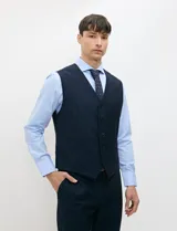 Chaleco formal sastrero Harrington Select de color azul marino, con cuello en V, cierre frontal de botones y bolsillos ribeteados.