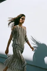 Vestido midi de Zara Woman Collection, con estampado de rayas verticales y detalles ornamentales, escote en V, mangas cortas con aberturas en los hombros, y fajín integrado con lazo lateral del mismo tejido.