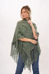 Ruana verde tejida en telar manual con lana merino. Presenta diseño con flecos y bolsillos de cuero natural.