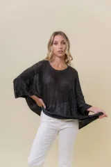 Buzo de tejido liviano color negro con brillo sutil tipo lurex, cuello redondo y calce suelto (oversize) con mangas amplias.