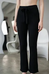 Pantalon de lanilla color negro, de corte acampanado y tiro alto. Presenta una cintura elástica con cordón ajustable y terminaciones con detalle de volados en el ruedo.