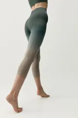 Calza deportiva corta de diseño seamless, con efecto degradado que transiciona del gris azulado en la parte superior al marrón en las piernas.