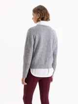 Sweater de tejido de punto gris con textura de pelo, cuello redondo y mangas largas. Presenta un bordado frontal de piedras brillantes con forma de flamas.
