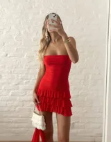 Vestido corto rojo con diseño strapless, escote tipo halter con banda al cuello, cuerpo ajustado con frunces y falda con volados en capas.
