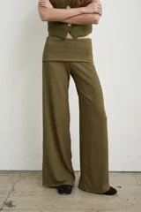 Pantalón palazzo negro de tiro alto con cintura ancha plegable, confeccionado en tela de punto fruncida y corte holgado.