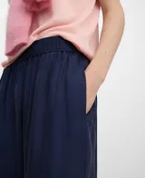 Pantalón palazzo azul marino de tiro alto con cintura elástica fruncida, bolsillos laterales y caída fluida.