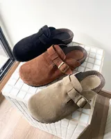 Zueco de cuero vacuno color negro, con diseño de punta cuadrada, hebilla metálica ajustable en el empeine y plantilla anatómica con base de corcho.