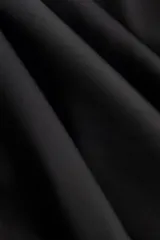 Minivestido halter de satén color negro, de corte holgado y diseño fluido con escote drapeado.