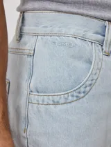 Bermuda de jean azul oscuro, de corte holgado y diseño clásico con cinco bolsillos y cierre frontal con botón.