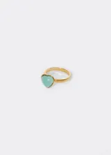 Anillo dorado con dije de corazón celeste.