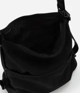 Bolso tipo hobo convertible a mochila, color negro, confeccionado en poliéster. Cuenta con cierre principal, bolsillo externo frontal y correas ajustables de cinta gross.
