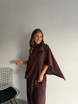 Poncho de cuello alto y diseño holgado con mangas tipo capa, confeccionado en tejido de algodón y poliéster color marrón.