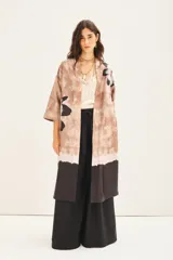 Kimono largo estampado con diseño floral, de corte recto y mangas amplias 3/4. Presenta un diseño de bloques de color con una base en tonos tierra y un borde inferior en color negro.