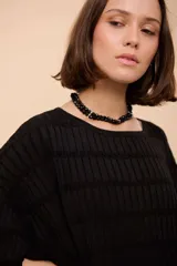 Remerón rojo con rayas horizontales turquesas, de corte recto y suelto, manga corta y cuello redondo.