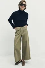 Pantalón culotte de tiro alto en color verde militar. Presenta bolsillos frontales de plastrón con solapa, cierre frontal con cremallera y botón, y diseño de pierna ancha con dobladillo marcado.