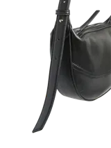 Bolso de hombro negro de efecto cuero, con forma curva y cierre de cremallera. Presenta costuras decorativas en el cuerpo y correa ajustable para llevar al hombro.