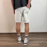 Short de algodón gris melange con cintura elástica y cordón de ajuste, de corte holgado y ruedo sin costura.