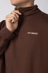 Buzo de cuello alto con cierre frontal parcial, manga larga y diseño holgado. Presenta un pequeño logo bordado en el pecho.