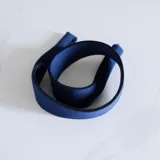 Cuerdita de tela azul marino con borde negro, diseñada como accesorio versátil.
