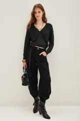 Cardigan negro de viscosa con poliéster metalizado, de manga larga, escote en V cruzado y lazo ajustable en la cintura.