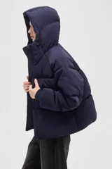 Campera puffer de color marrón oscuro, con diseño capitoneado, cierre frontal, capucha ajustable y bolsillos laterales con cierre.