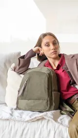Mochila de diseño funcional confeccionada en tafeta, color verde oliva. Cuenta con compartimento principal con cierre, dos bolsillos frontales con cierres metálicos, bolsillos laterales y un bolsillo adicional en el dorso. Incluye correas regulables y tiradores de cierre en cuero sintético.
