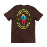 Remera de algodón color marrón con estampa gráfica en la espalda que presenta un diseño ovalado con el texto 'Puerto Rico Seguimo Aquí 2025' y una ilustración de una rana con ropa urbana.