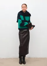 Jersey de punto de corte recto con diseño de rayas horizontales en verde y azul marino. Presenta cuello redondo y manga larga.