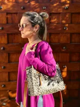 Cartera tipo tote bag con estampado animal print, doble asa de mano color cuero y correa larga desmontable y regulable.