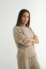 Conjunto de dos piezas compuesto por un sweater de cuello alto con aberturas laterales en el ruedo y un pantalón de corte recto y holgado, ambos confeccionados en tejido de punto suave.