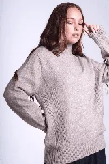 Sweater color beige de tejido de punto con cuello alto y mangas largas. Presenta detalles de ochos en diagonal en los laterales.