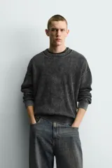 Sweater relaxed fit de canalé, color negro con efecto lavado, cuello redondo y manga larga con acabados en rib.