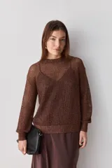 Sweater calado de punto negro, con cuello redondo y mangas largas, de diseño liviano ideal para superposiciones.