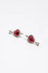 Caravanas de metal plateado con diseño de corazón rojo esmaltado, rodeado de cristales brillantes y atravesado por una flecha.