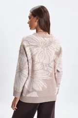 Buzo de punto con diseño jacquard de flores en tonos beige y crema, de corte holgado, cuello redondo y mangas largas con puños acanalados.