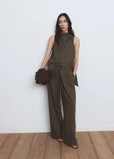 Pantalón de corte recto y pernera ancha, color verde militar con sutiles rayas verticales. Cuenta con cintura elástica con cordón ajustable y bolsillos laterales.