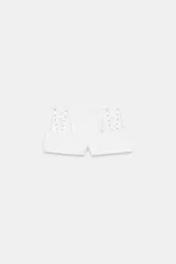 Shorts mini de tiro bajo color blanco, con detalles de cordones cruzados en los laterales delanteros y bolsillos de plastrón en la espalda. Con cierre frontal con cremallera y gancho metálico.
