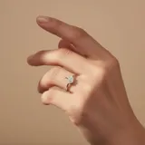 Anillo de plata 925 con diseño de árbol en la parte superior, adornado con pequeñas piedras brillantes.