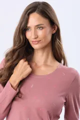 Remera de manga larga en color rosado, con cuello redondo y estampado sutil en tono sobre tono.